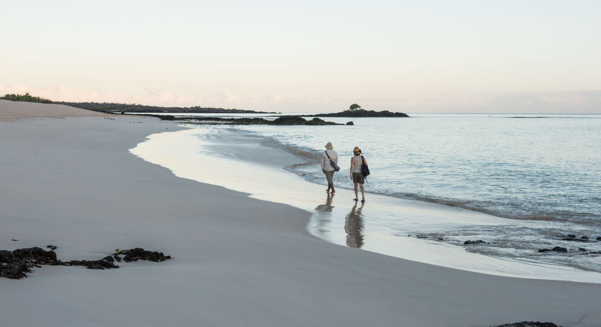 Bachas Beach - Santa Cruz in Galapagos Island beautiful white sand beach and tourist walking