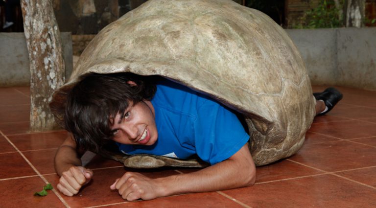 Cerro colorado - San Cristobal in the Galapagos Islands, tourist inside of giant tortoise shell