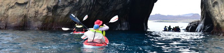 tourists kayaking towards the Kicker rock in Galapagos