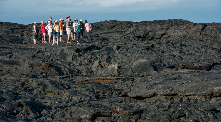 Sullivan bay in Santiago Island have a solid volcanic lava with tourist exploring the terrain