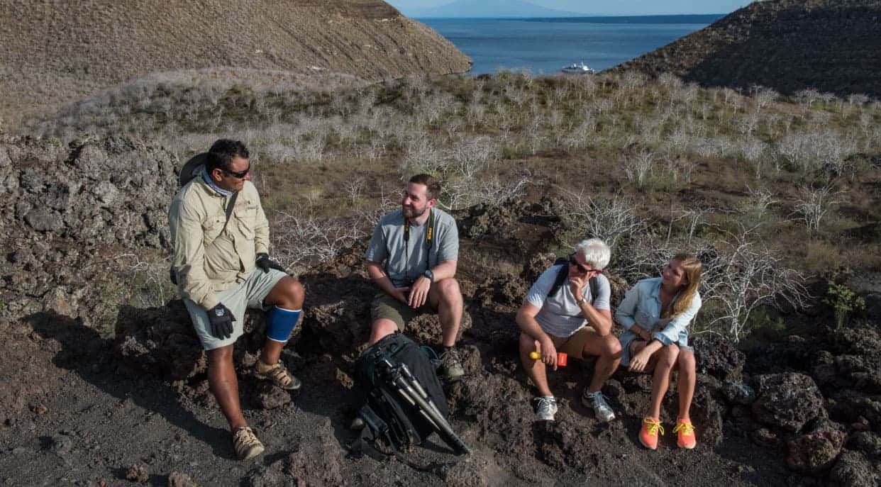 Tagus Cove - Isabela in the Galapagos Islands, tourist talking with a experienced guide while resting